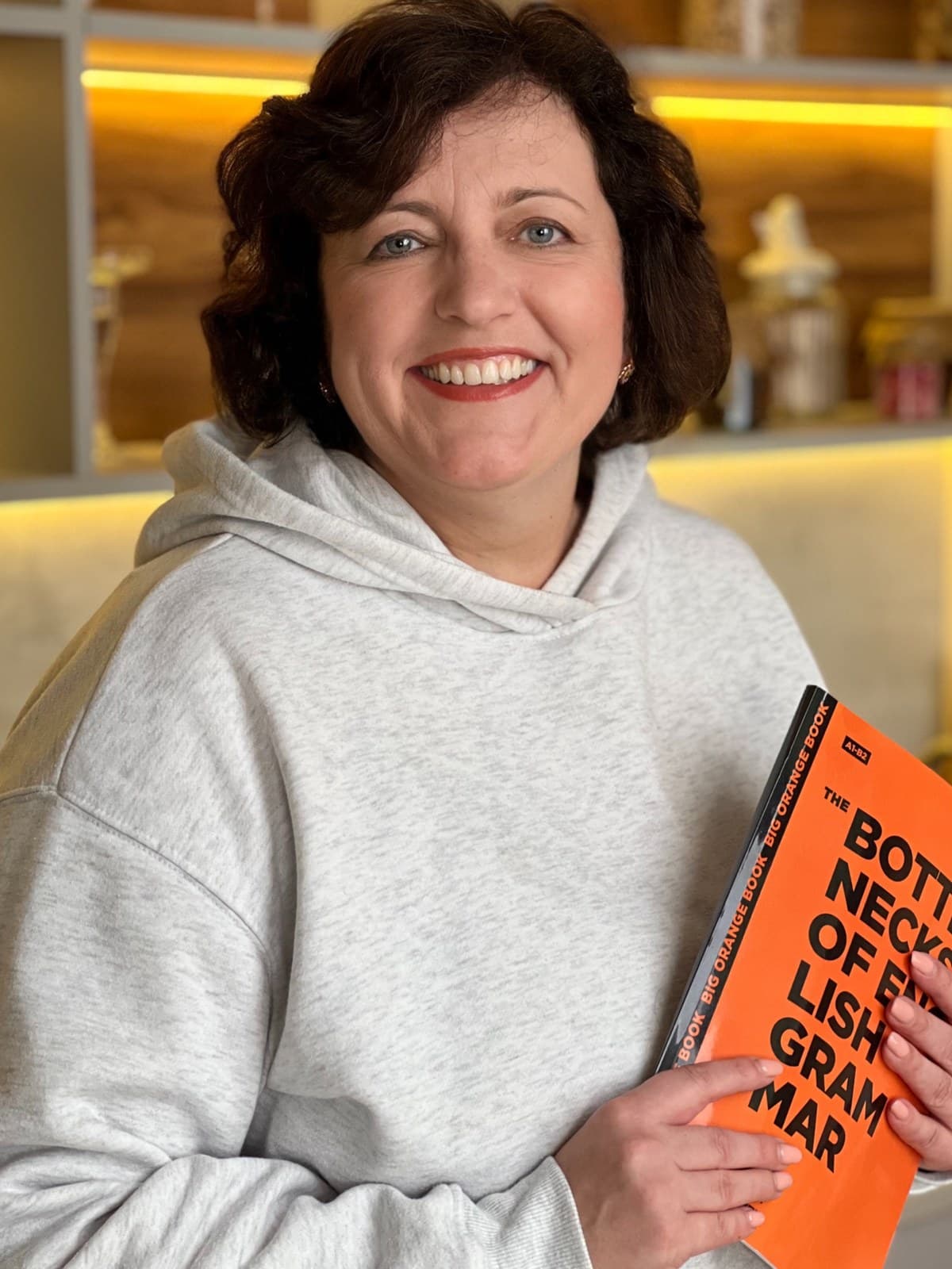 Olha Oliinyk, co-founder of the school, holding the Bottlenecks of English Grammar coursebook